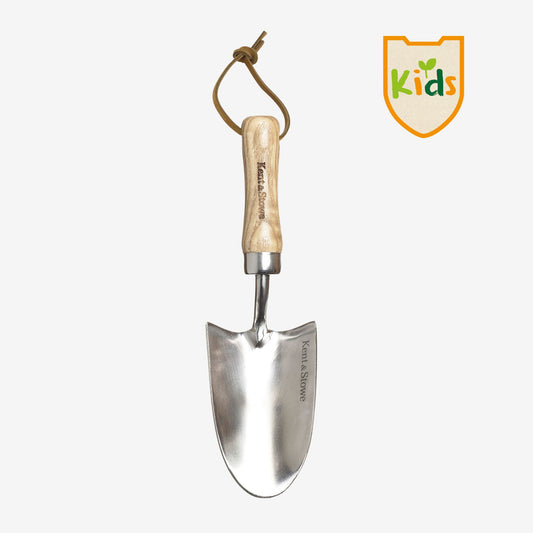 A kent and stowe stainless steel hand trowel with a rounded head and a durable ash wood handle, with a label that says 'Kids'.