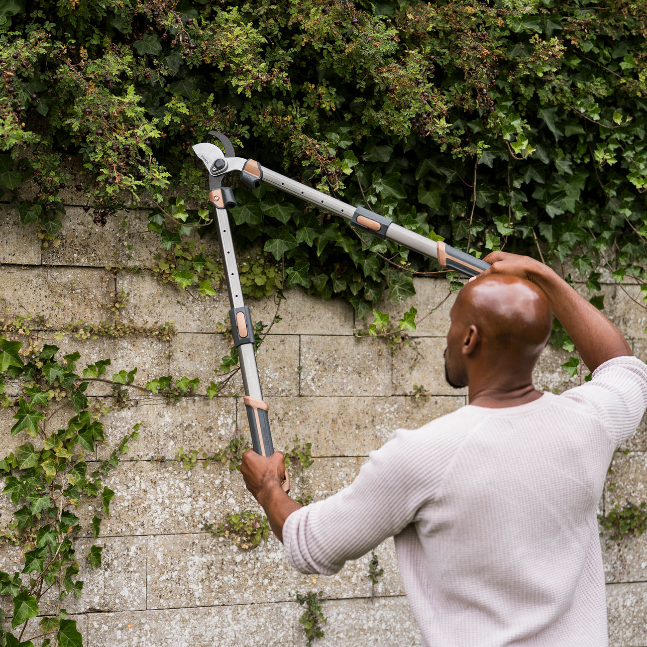 Kent & Stowe SureCut All Purpose Extra Power Loppers man cutting bush with telescopic handles close up