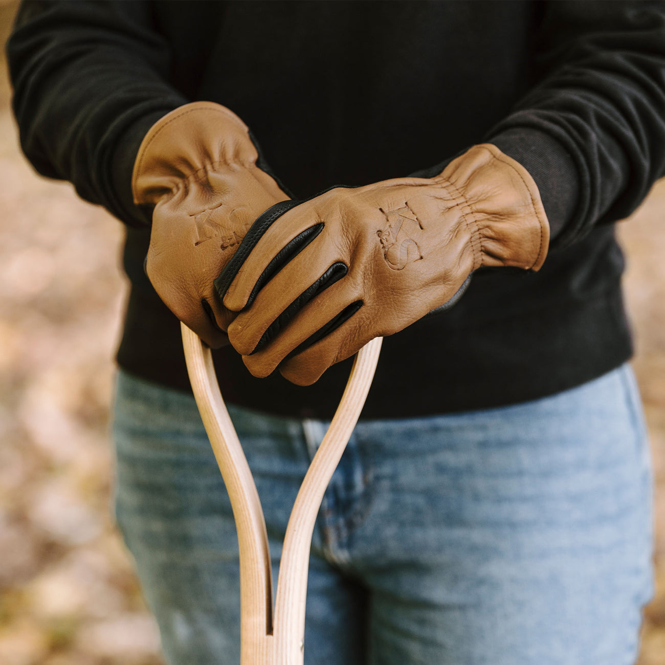 woman wearing gloves holding digging spade